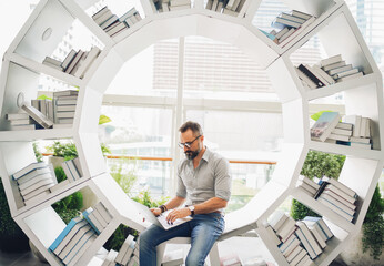 Lifestyle of man hipster freelancer standing and holding laptop at office terminal corporate, professional freelance man concept