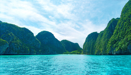 Wall Mural - Wide screen sea beach and background cliff mountain with cloudy sky , Maya beach local area in Krabi Thialand.