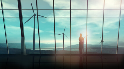 Wall Mural - in a spacious room against the window, a business woman looks at wind turbines.