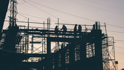 Wall Mural - Silhouette Engineer and construction team working at site over blurred  industry background with Light fair Film Grain effect.Create from multiple reference images together