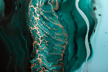 Acrylic Fluid Art. Dark green waves in abstract ocean and golden foamy waves. Marble effect background or texture