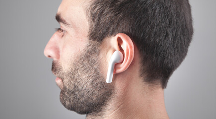 Wall Mural - Caucasian man wearing white wireless earphone.