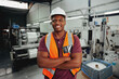 © StratfordProductions - Cheerful confident young african male industrial worker looking at camera with his arm crossed