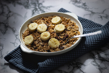 plate of a muesli with chocolate and raisins and bananas