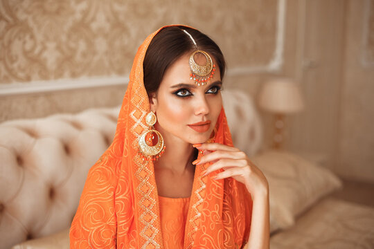 Portrait of beautiful indian girl in traditional saree in luxury interior. Young hindu woman model with kundan golden jewelry set. Indian costume lehenga choli.
