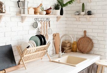 Rustic kitchen interior with white brick wall and white wooden shelves