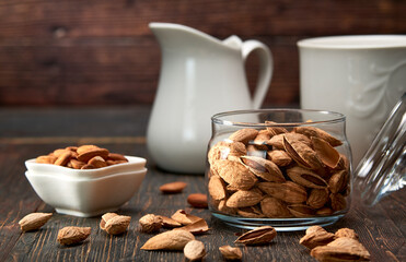 Almonds-nut kernels lie on wooden planks, against the background of glass dishes.