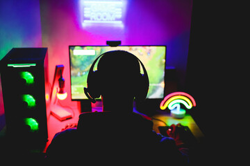 Streamer gamer playing at strategy game in broadcast browser - Young man having fun gaming and streaming online with computer - Technology, e sports and entertainment concept - Focus on his head