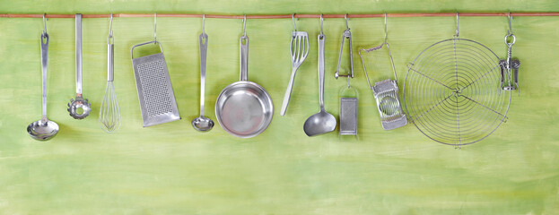 Wall Mural - restaurant kitchen utensils on green painted wall, free copy space