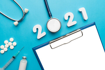 Wall Mural - 2021 Happy New Year banner for health care and medical concept. Stethoscope with doctor order chart, prescription, pills, syringe, vaccine vial and white number 2021 on table blue background.