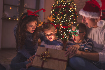 Wall Mural - Family opening magical glowing Christmas present