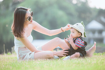 Mother and son are lying on the grass in the park.