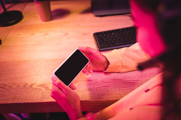 Wall Mural - Smartphone with blank screen in hands of gamer on blurred foreground