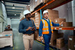 © StratfordProductions - Multiracial workers discussing about warehouse stock wearing safety helmets