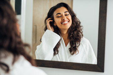 Wall Mural - Beautiful middle east woman with closed eyes standing in front of a mirror