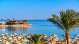 Fototapeta  - Relaxing at paradise beach - Chaise lounge and parasols - travel destination Hurghada, Egypt