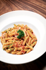 Wall Mural - penne amatriciana tomato and ham sauce pasta on wood table