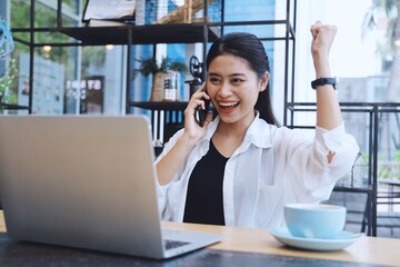 Asian woman in white shirt using laptop.