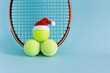 three smiley yellow tennis balls in santa hat with racket , xmas decoration, tennis sport concept