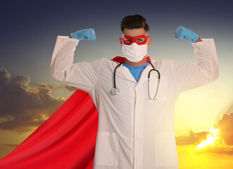 Canvas Print - Medical workers fighting with dangerous diseases. Doctor dressed as superhero posing against sky