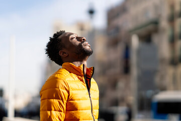 African man breathing fresh air outdoors standing in the city