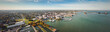 Incredible aerial city skyline panorama photograph of Sandusky, Ohio from the shoreline of the bay in Lake Erie with parks and harbors seen below on a sunny day.