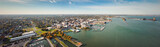 Fototapeta  - Incredible aerial city skyline panorama photograph of Sandusky, Ohio from the shoreline of the bay in Lake Erie with parks and harbors seen below on a sunny day.