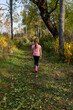© kellyvandellen - Young Girl Walks Along Grassy Trail