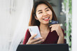 © doucefleur - smile Asian girl happy shopping online from home hand holding credit card and smart phone