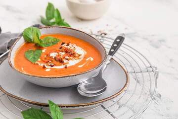 Bowl of tasty tomato cream soup on table