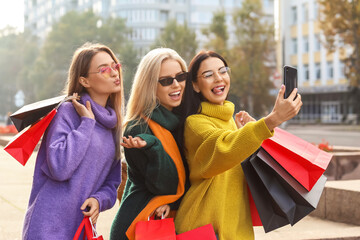 Wall Mural - Beautiful young women taking selfie outdoors after shopping