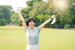 © myboys.me - Beautiful portrait of a wellbeing Asian woman relaxing released her face mask off and raised her hands up with joyful in the park. New normal lifestyle during Covid-19 pandemic. Health insurance.