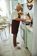 © Viacheslav Yakobchuk - Nice old woman in apron cooking dinner at home