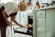 © Viacheslav Yakobchuk - Joyful elderly woman baking pies in kitchen at home