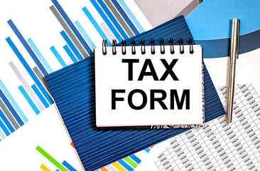 Poster - Notepad with text Tax Form lying on financial tables with a pen. Business and financial concept