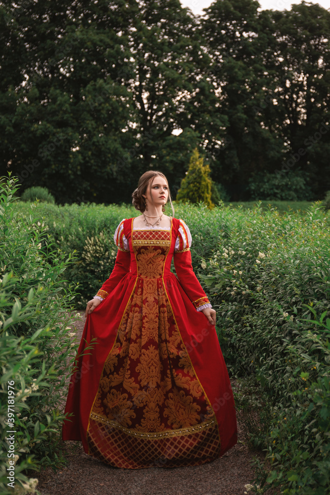 beautiful young woman in a red medieval dress is standing in the park,  fantasy princess Stock Photo | Adobe Stock