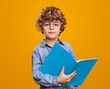 © kegfire - Clever schoolboy with textbook looking at camera