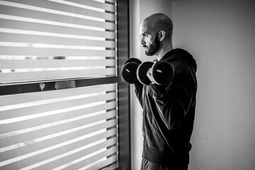 Wall Mural - Portrait of a man exercising with weights indoor