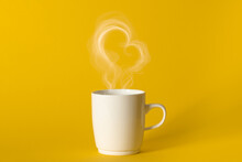 Steaming Coffee Cup On Yellow Background. White сoffee Cup With Steam. Smoke From Hot Coffee. Front View, Copy Space