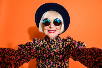 Canvas Print - Portrait of happy smiling cheerful positive grandmother take selfie wear sunglasses isolated on orange color background