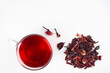 Hibiscus tea cup and dried flowers on white background. Vitamin, recipe, beverage concept. Top view, flat lay, copy space