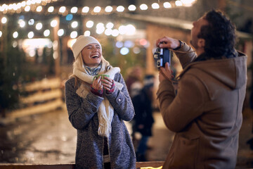 Wall Mural - Young couple having fun on a winter night; Winter joy concept