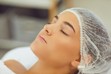 Wall Mural - Close-up of womans face relaxing with eyes closed after skincare procedure or massage