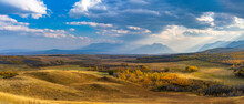 Vast Prairie And Forest In Beautiful Autumn. Sunlight Passing Blue Sky And Clouds On Mountains. Fall Color Landscape Background. Waterton Scenic Spot, Waterton Lakes National Park, Alberta, Canada.