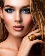 Wall Mural - Photo of young woman with style make-up. Portrait of blonde woman with a beautiful face. Closeup face with stylish blue makeup. Fashion model with long hair, studio shot.