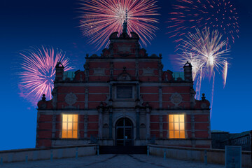 Celebratory fireworks for new year over The Borsen, Oldest Building in Slotsholmen, in Copenhagen, Denmark with the famous dragon spire up roof during last night of year. Christmas blue atmosphere 