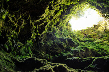 Dark And Rough Texture With Moss Wall In Tunnel Opening To The Outside Light In Algar Do Carvão, Terceira - Azores PORTUGAL