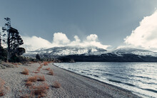 Wonderful Scenery Of Coast Near Sea On Background Of Mountain Range Covered With Snow In Patagonia