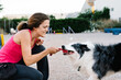 © Victor Gonzalez/ADDICTIVE STOCK - Border Collie dog pulling rope from hand of female instructor during training on playground with agility equipment