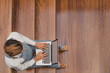 © Si And Si/ADDICTIVE STOCK - High angle of female freelancer sitting on wooden staircase in modern building and working on project while using netbook